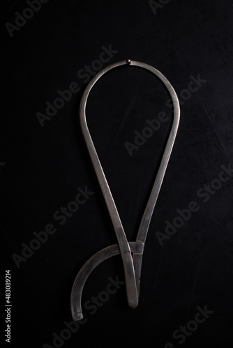 obstetric pelvis meter metal on a black background, close-up. Intsrument for pregnant women photo