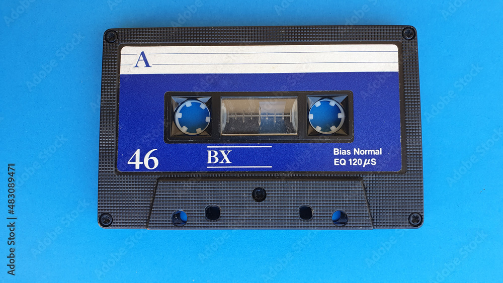 Obraz premium Retro audio cassette tapes on blue background. Vintage media device. Space to write on the label.