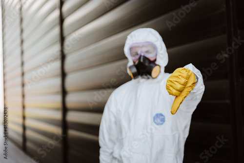 Obraz na płótnie man in a protective suit in front of a building with yellow glowers