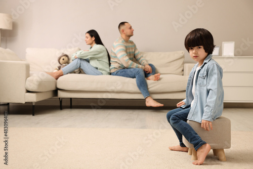 Sad couple with relationship problems at home, focus on their upset child