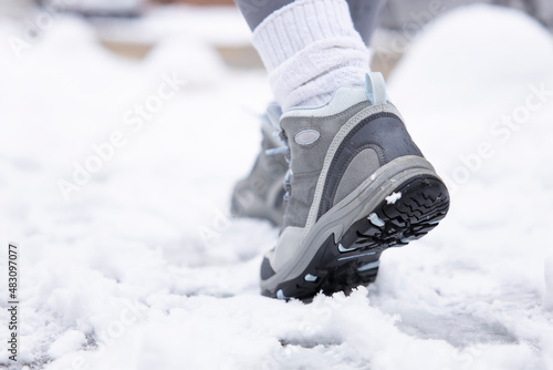 Woman walking on snowy road, wintertime