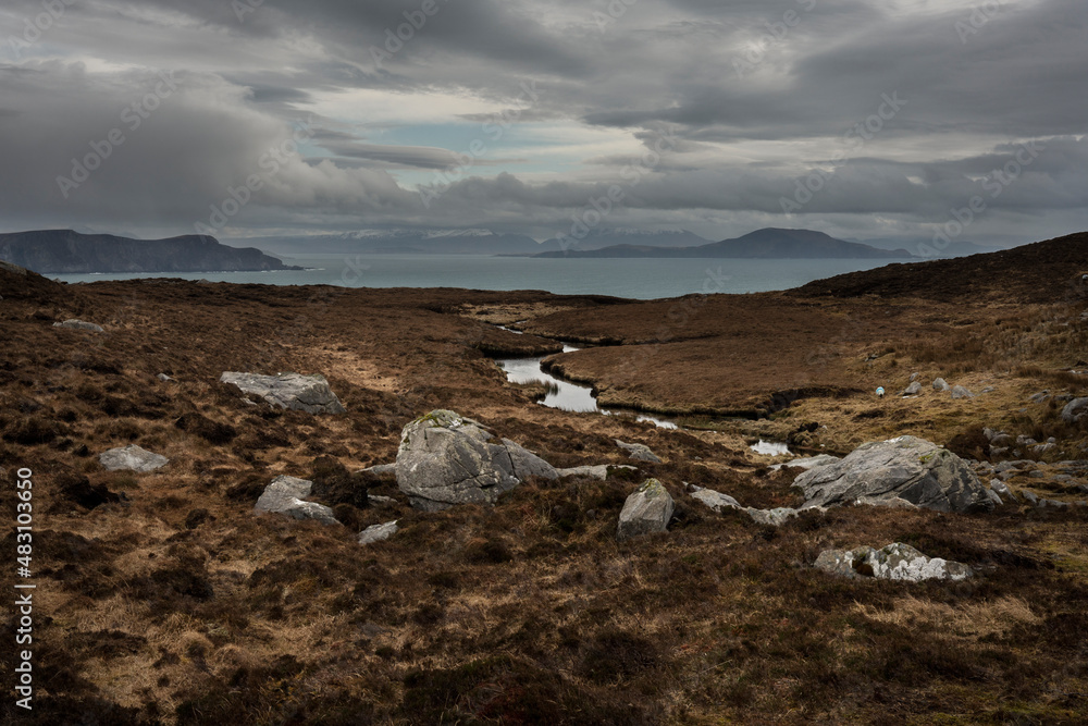 Dramatic Light On A Gloomy Winter Day In Ireland. View from the mountains around Lough Acorrymore on Achill Island, County Mayo in Ireland.The lake supplies water to Achill and the surrounding areas.