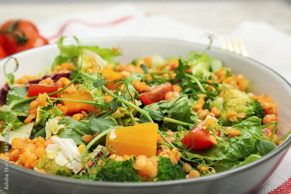 Delicious salad with lentils and vegetables in bowl, closeup