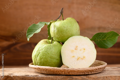 Obraz na plátně Fresh organic guava fruit in basket on wooden background, Tropical fruit