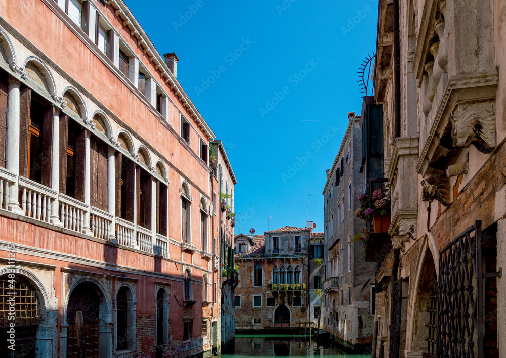 Naklejka premium Typical Venetian atmosphere, narrow canal and windows of the houses towards the water, Venezia ,Italy
