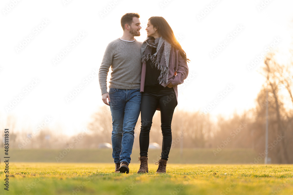 Young couple walking and looking at each other in a park on san valentine's day Young couple walking and looking at each other in a park on san valentine's day