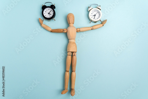 Fototapeta Naklejka Na Ścianę i Meble -  Time and wooden mannequin alarm clock. A matter of time. Space for copying text