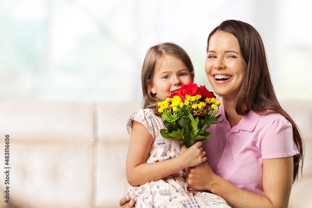 Loving little child hugging happy mom and greeting with a bouquet Loving little child hugging happy mom and greeting with a bouquet