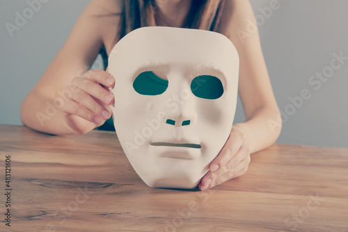 young girl holding anonymous mask