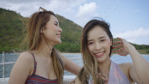 Two beautiful Asian women sit on a speed boat preparing to go the islands in the sea.