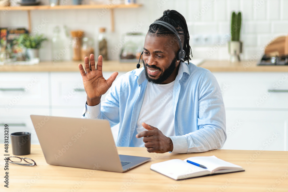 Happy African American teacher man teaching remotely at home using laptop computer greets students before the lecture, video call, e-learning concept Happy African American teacher man teaching remotely at home using laptop computer greets students before the lecture, video call, e-learning concept