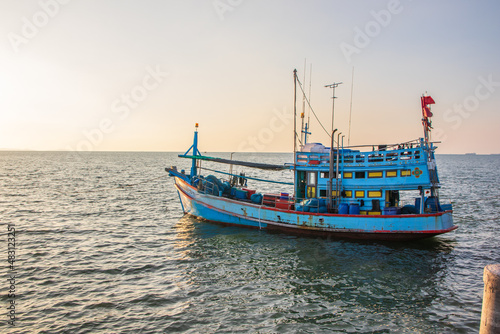 In the evening, colorful fishing boats are securely tied down directly at the pier with seaman's ropes and knots