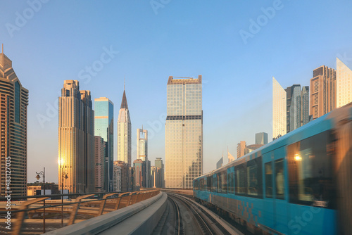 Metro System. View from window of subway car in Dubai in evening rays of sunset. Underground station train goes past skyscrapers. Departing train rushes towards. High quality photo