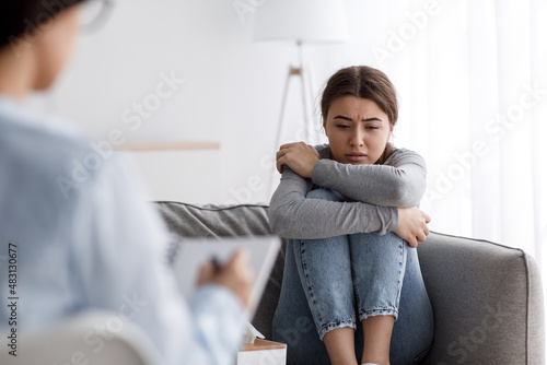 Fototapeta Confused european young lady suffering from depression, mental problems, crying