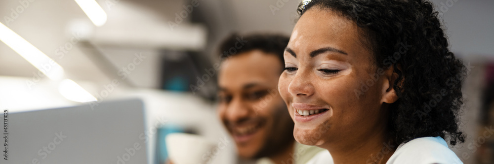 Middle eastern man and woman smiling while working with laptop together Middle eastern man and woman smiling while working with laptop together