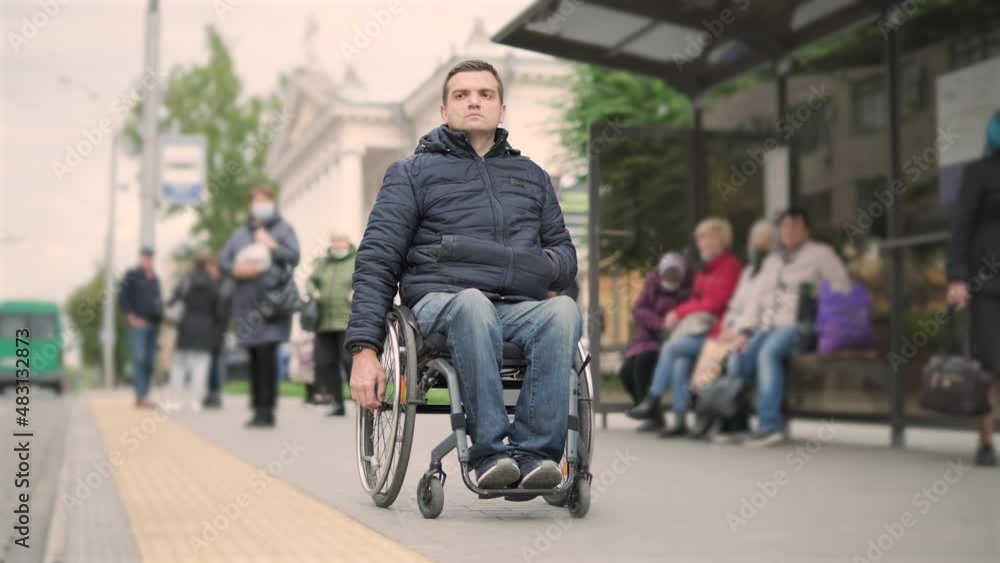 Person with a physical disability waiting for city transport with an accessible ramp Person with a physical disability waiting for city transport with an accessible ramp