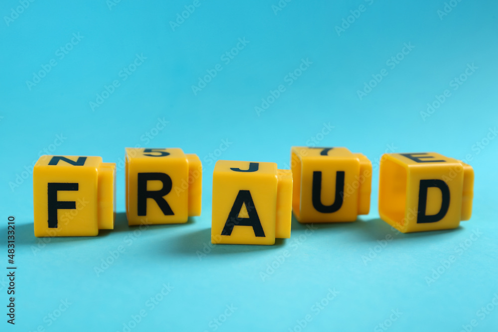 Obraz premium Word Fraud of yellow cubes with letters on light blue background
