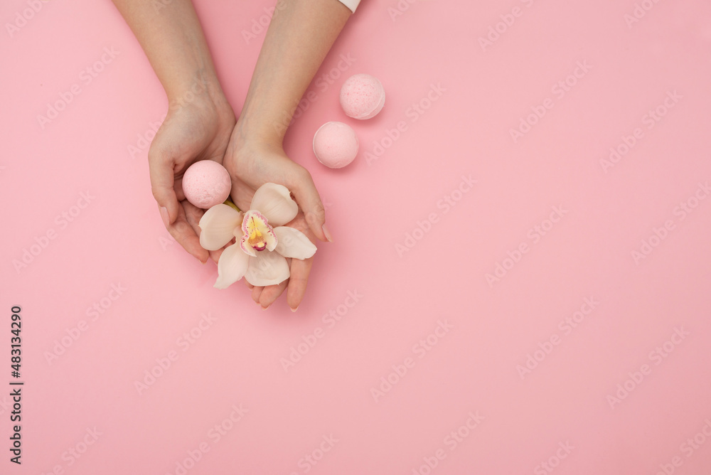 Hands with flower and bath bomb on pink background Spa concept Hands with flower and bath bomb on pink background Spa concept
