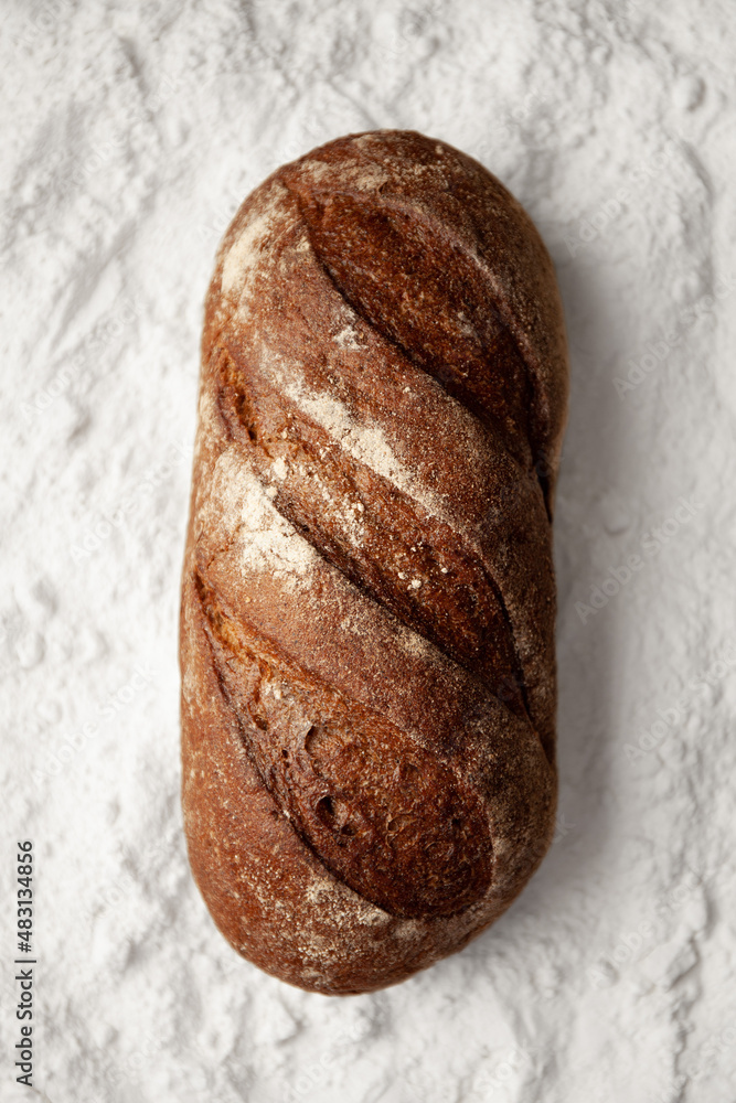 Rye black bread on a background of white flour. Rye black bread on a background of white flour.