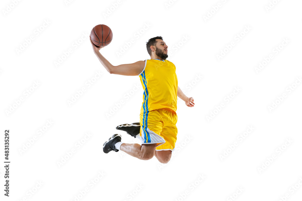 Young sportive man, professional basketball player jumping with ball isolated on white studio background. Sport, motion, activity, movement concepts.