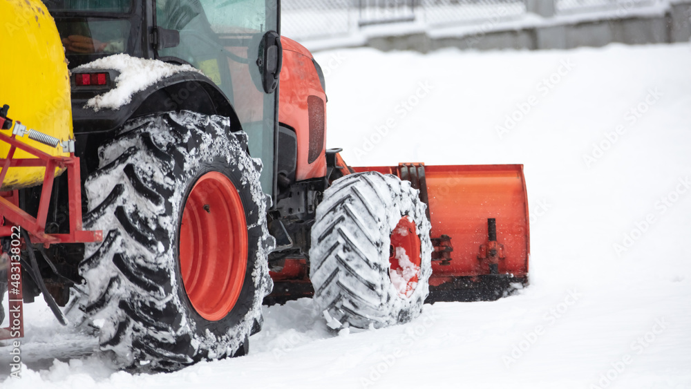 Tractor cleaning urban park paths on a cold snowy day. Tractor cleaning urban park paths on a cold snowy day.