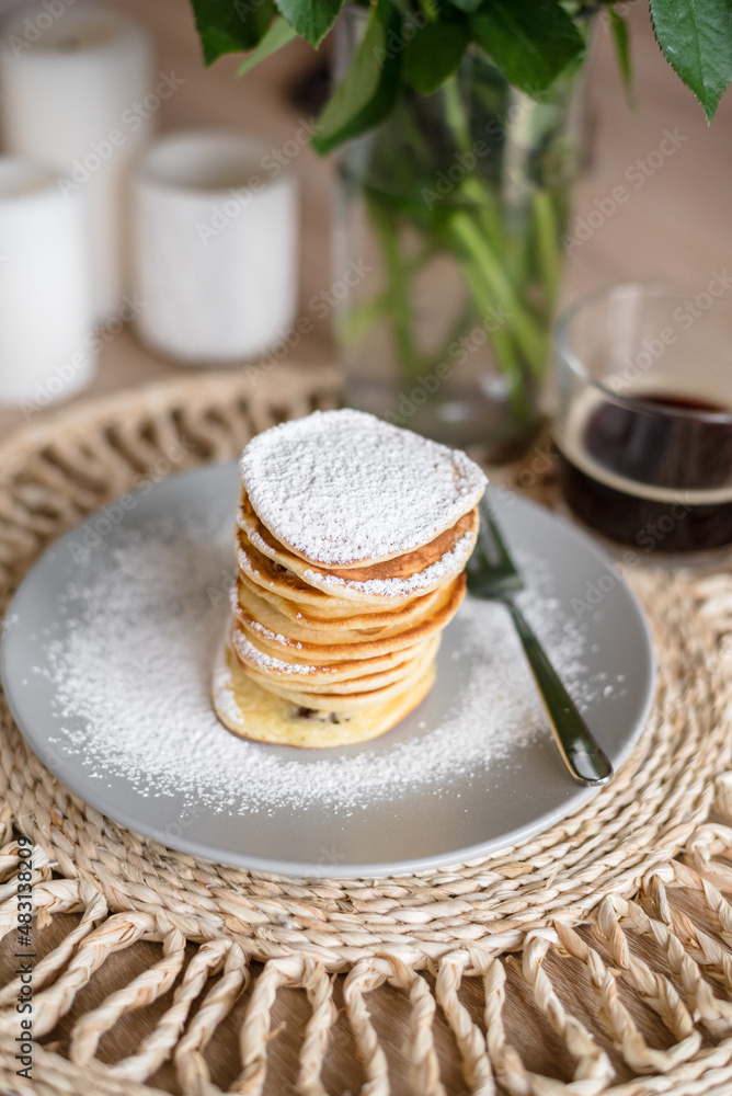 Stack of pancakes with sugar powder and cup of coffee. Close up. Breakfast concept. Home made pancakes.