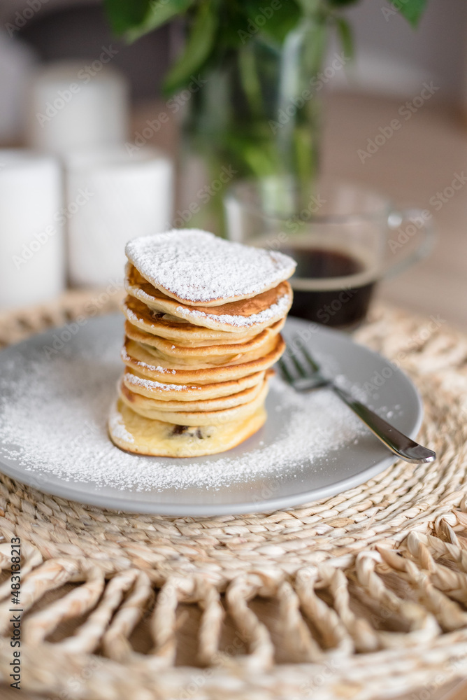 Stack of pancakes with sugar powder and cup of coffee. Close up. Breakfast concept. Home made pancakes. Stack of pancakes with sugar powder and cup of coffee. Close up. Breakfast concept. Home made pancakes.