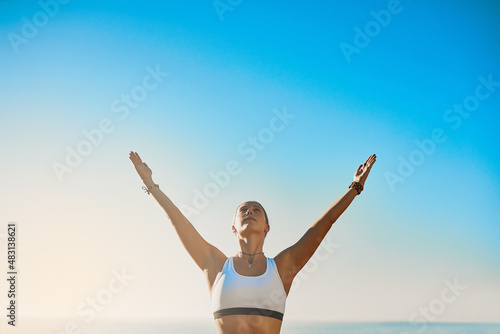 Invest your energy in the present. Shot of an athletic young woman practicing yoga on the beach. © Ruan J/peopleimages.com