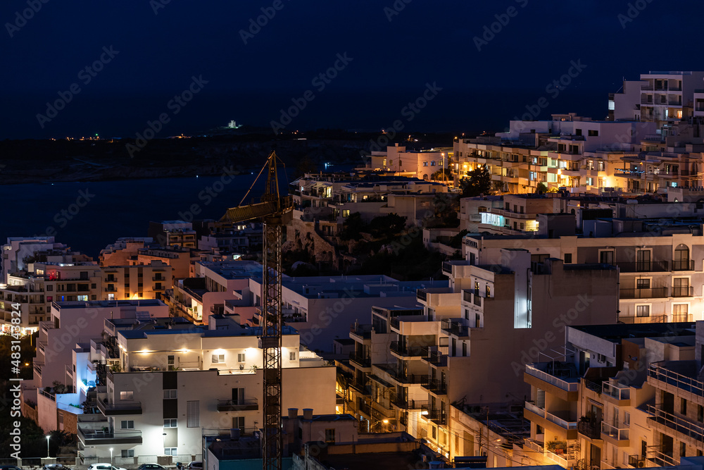 Mellieha, Malta - 01 07 2022: High angle view by night over the valley towards the seaside