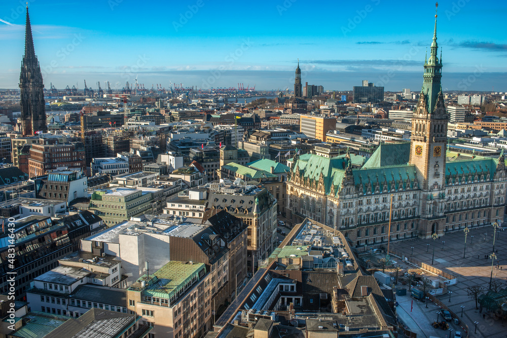 Panoramaaufnahme von Hamburg, mit dem Hamburger Rathaus mit blauem, leicht bewölktem Himmel, von oben aufgenommen (Aufnahme vom Januar 2022)