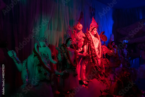 Goddess Durga idol at decorated Durga Puja pandal, shot at colored light, at Kolkata, West Bengal, India. Durga Puja is biggest religious festival of Hinduism and is now celebrated worldwide.