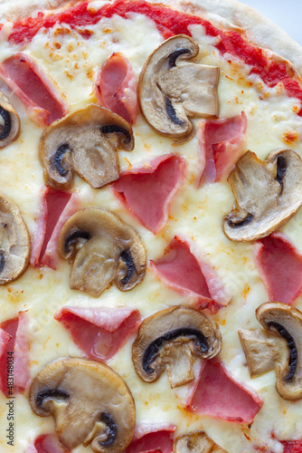 Prosciutto and mushroom pizza on a marble background