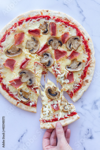 Prosciutto and mushroom pizza on a marble background