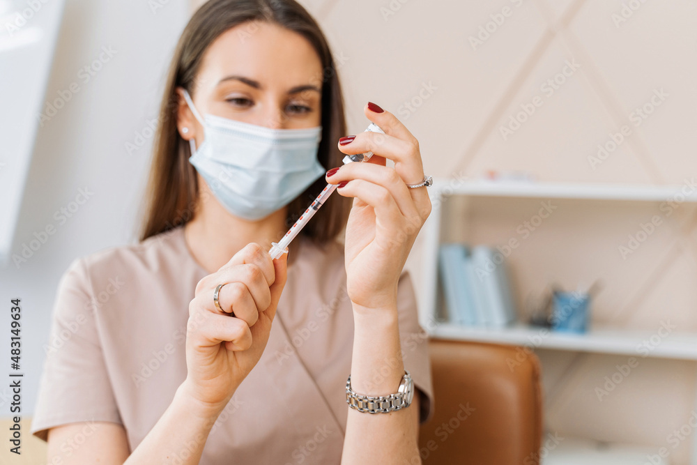Photo of a beautiful lady doctor in the hospital preparing a syringe