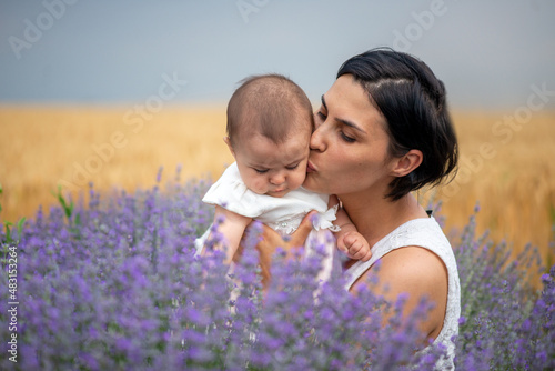 Happy mother with pretty daughter on lavender background.