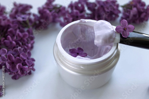 Cream with lilac extract on a light background photo