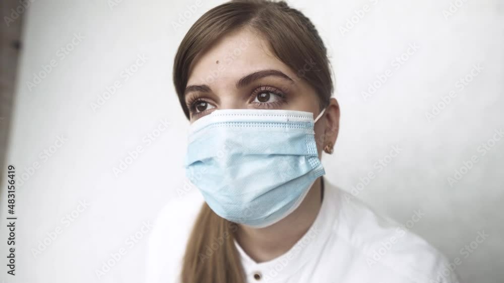 Portrait of tired exhausted nurse or doctor looking out the window. COVID-19, Coronavirus pandemic omicron Portrait of tired exhausted nurse or doctor looking out the window. COVID-19, Coronavirus pandemic omicron