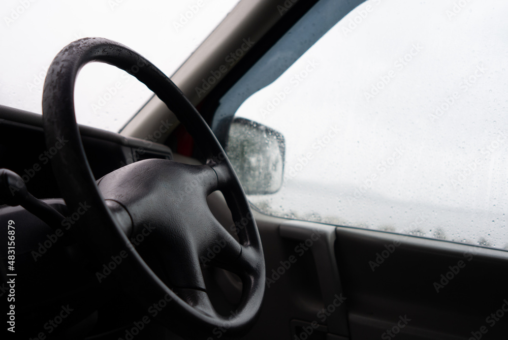 interior of a camper van looking out through wet rainy windows 