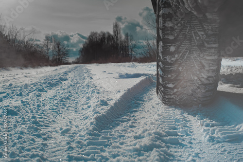 Closeup of car tires in winter on the road covered with snow © Алексей Ковалев