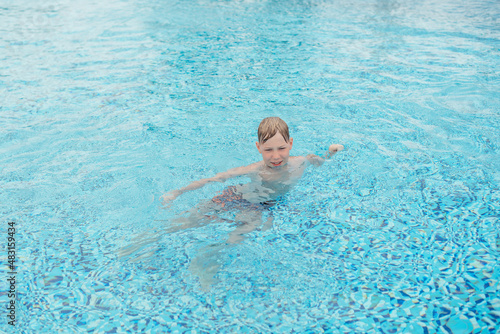  boy splashing in swimming pool 