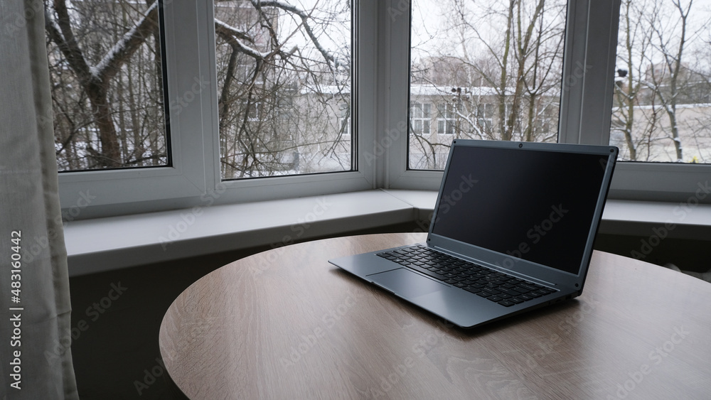 Fototapeta premium Open laptop on the table by the window