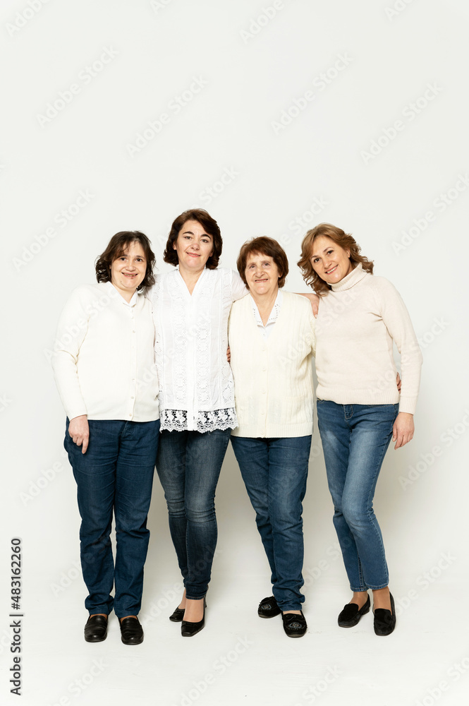 grandmother with daughters stands in full growth on a white background. lovely family. group of women of different ages. grandmother with daughters stands in full growth on a white background. lovely family. group of women of different ages.