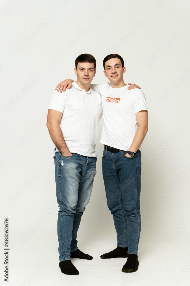 two brothers on a white background. older brother with younger. portrait of two friends. two brothers on a white background. older brother with younger. portrait of two friends.