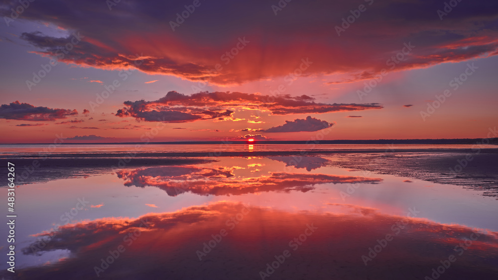 Sun rays and reflection of the sky in the water during a red sunset on the Gulf of Finland of the Baltic Sea.