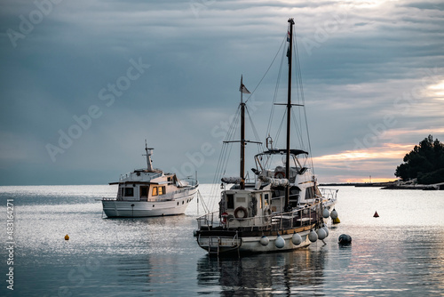 Beautiful winter sunset above calm, adriatic sea with anchored fishing boats before the nightfall in the Rovinj city port