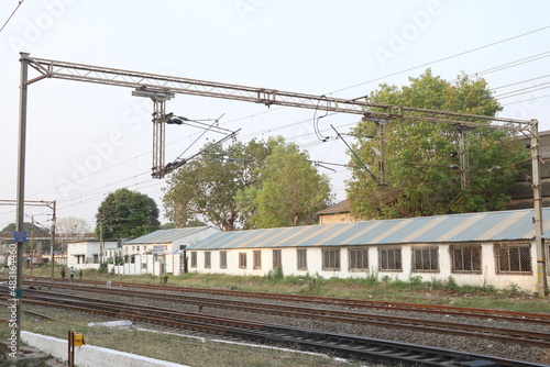 Railway electrification system. Power line wire over rail track. High metal construction transporting voltage energy.
