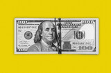 Gray dollar cash banknotes on yellow background.