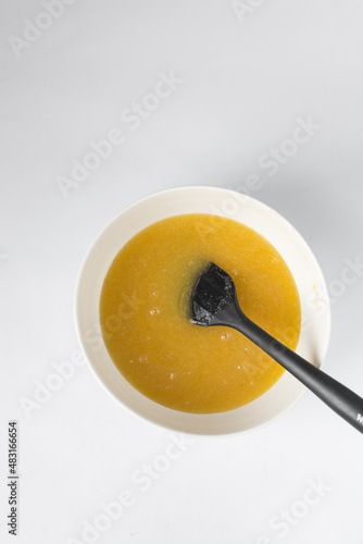 Melted butter  white sugar and an egg mixed in a white bowl