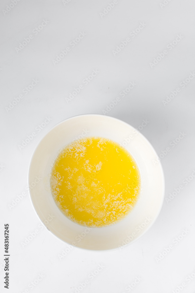 Melted butter in a white bowl, liquid butter Melted butter in a white bowl, liquid butter