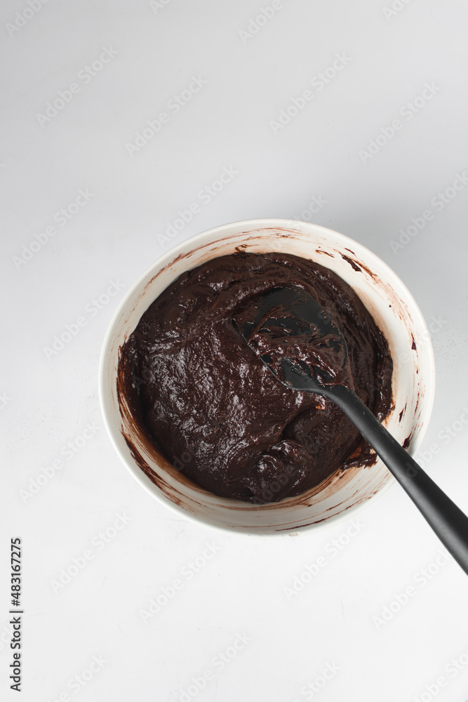 Fototapeta premium Raw brownie batter in a bowl, Making brownies in a white bowl